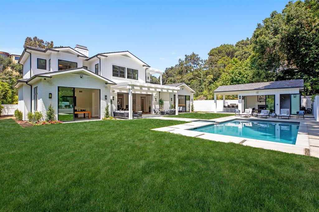 Bel-Air new construction rear exterior with white farmhouse siding, black steel windows, and pool