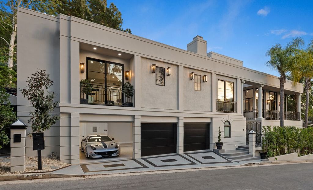 Beverly Hills remodel front elevation at dusk with black aluminum-clad windows and juliet balconies above the garage court