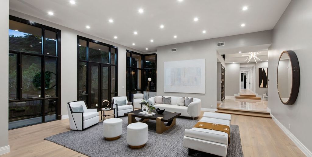 Living room with a wall of black aluminum-clad divided-light doors opening to the garden, Beverly Hills remodel