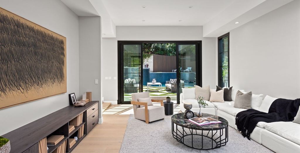 Family room with a black aluminum-clad sliding door opening to the pool terrace, Beverly Hills remodel