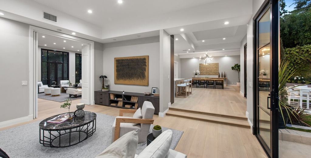 Open-plan living and dining with a black aluminum-clad door open to the side patio, Beverly Hills remodel