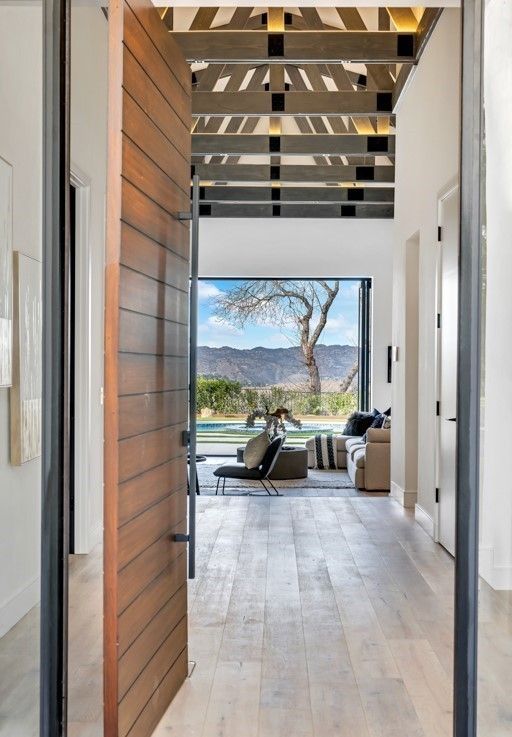 Entry hall framing a mountain view through pocketing glass doors, Calabasas
