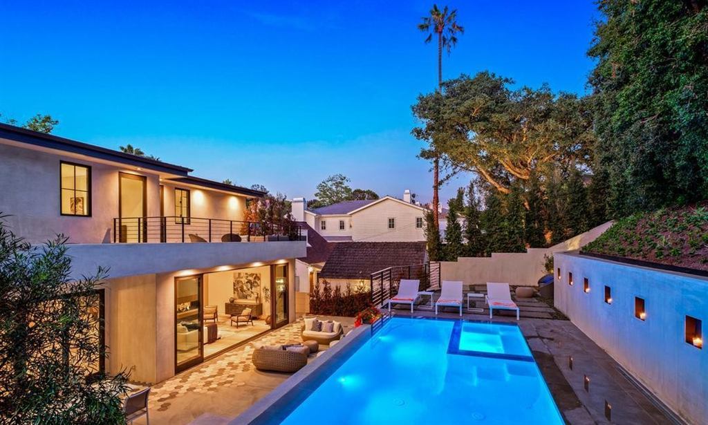 Twilight pool and patio view with dark aluminum-framed glass wall lit from inside, Cheviot Hills new construction