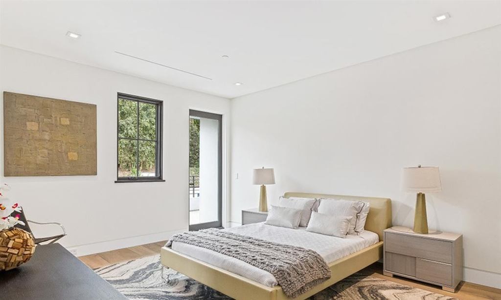 Bedroom with dark aluminum casement window and glass door opening to a balcony, Cheviot Hills