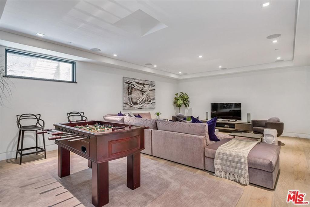 Lower-level media and game room with a large aluminum-framed clerestory window, Cheviot Hills