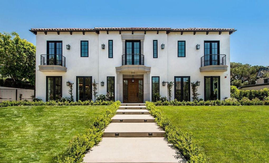 Daytime front elevation showing symmetrical Kolbe wood windows and French doors across a two-story white stucco facade, Hancock Park