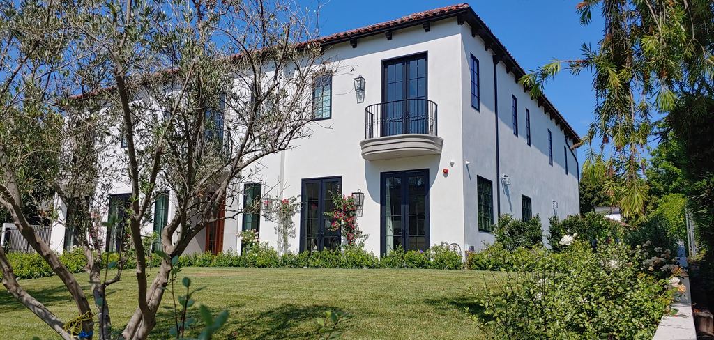 Side elevation with full-height Kolbe wood windows and a wrought-iron Juliet balcony door, Hancock Park new construction
