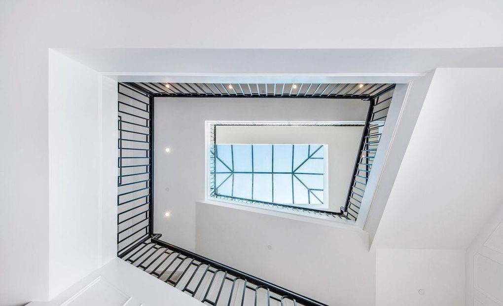 View up the stairwell to a gridded skylight above the top-floor landing, Hancock Park new construction