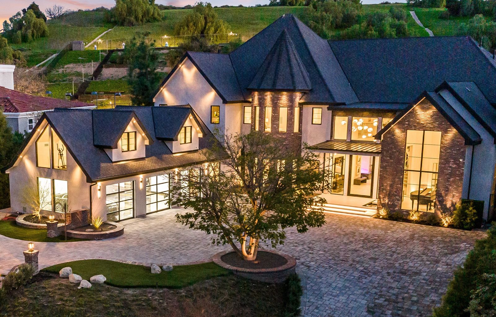Aerial view of a Woodland Hills estate remodel at dusk with steel-look aluminum windows and glass garage doors