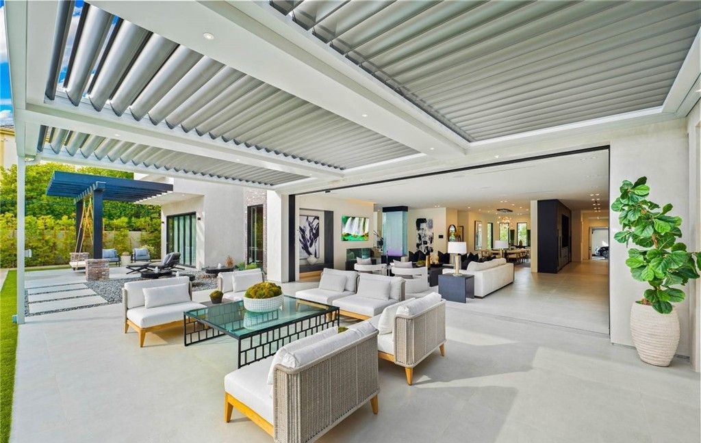 Indoor-outdoor living area with pocketing sliding glass walls under a louvered pergola, Woodland Hills
