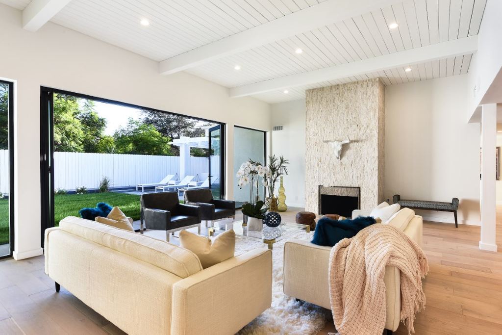 Living room with a black aluminum multi-slide door wall folded open to the backyard, Los Feliz remodel