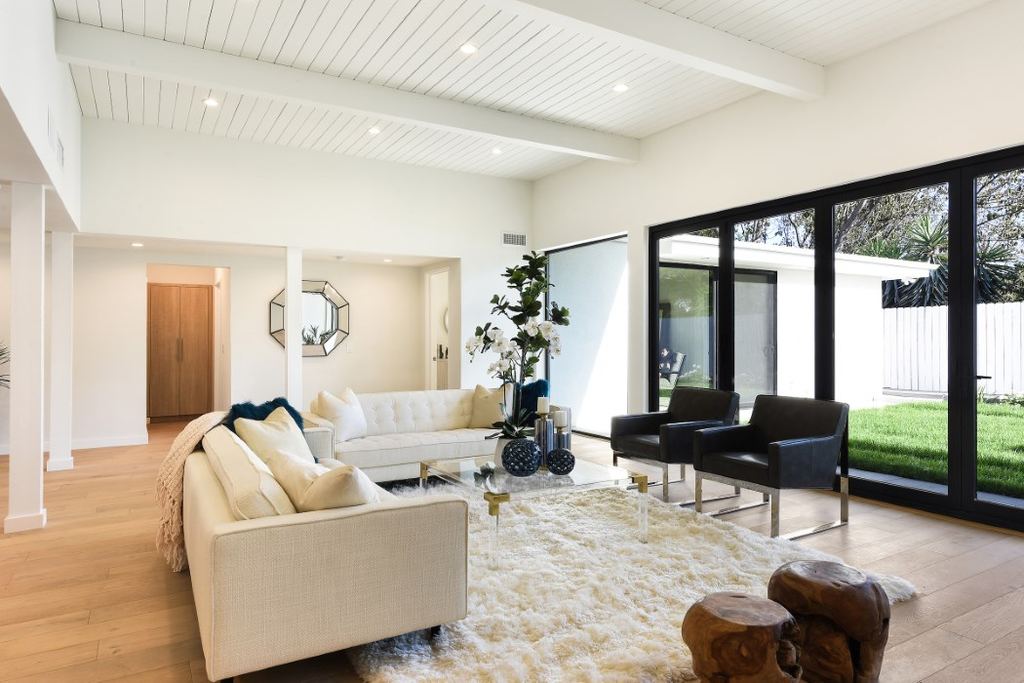 Living room with black aluminum sliding doors and windows framing the backyard, Los Feliz remodel