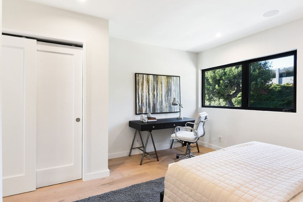 Bedroom desk nook beside a black aluminum casement window overlooking mature landscaping, Los Feliz remodel