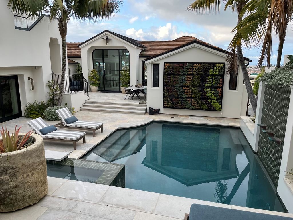Newport Beach new construction rear patio and pool with black steel doors and windows opening off the loggia