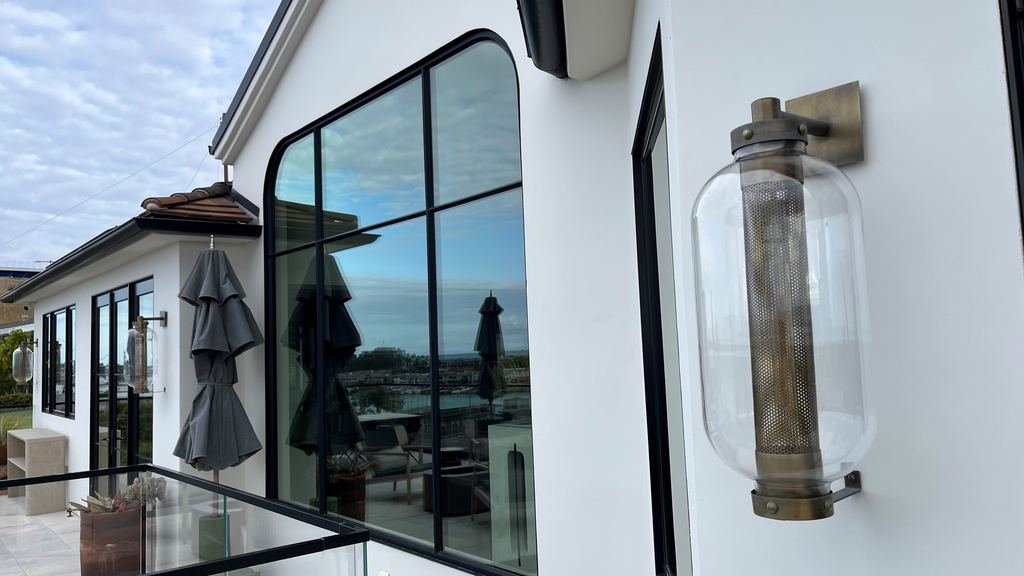 Detail of an arched black steel window and door on the balcony overlooking the harbor, Newport Beach new construction