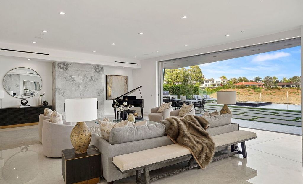 Living room in Pacific Palisades with Arcadia aluminum sliding doors drawn open to the pool terrace