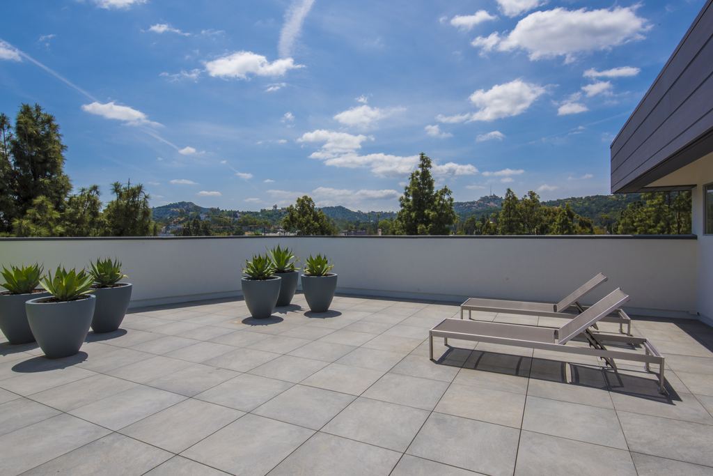 Rooftop terrace with paved deck and planters looking toward the Hollywood Hills, Studio City multifamily project