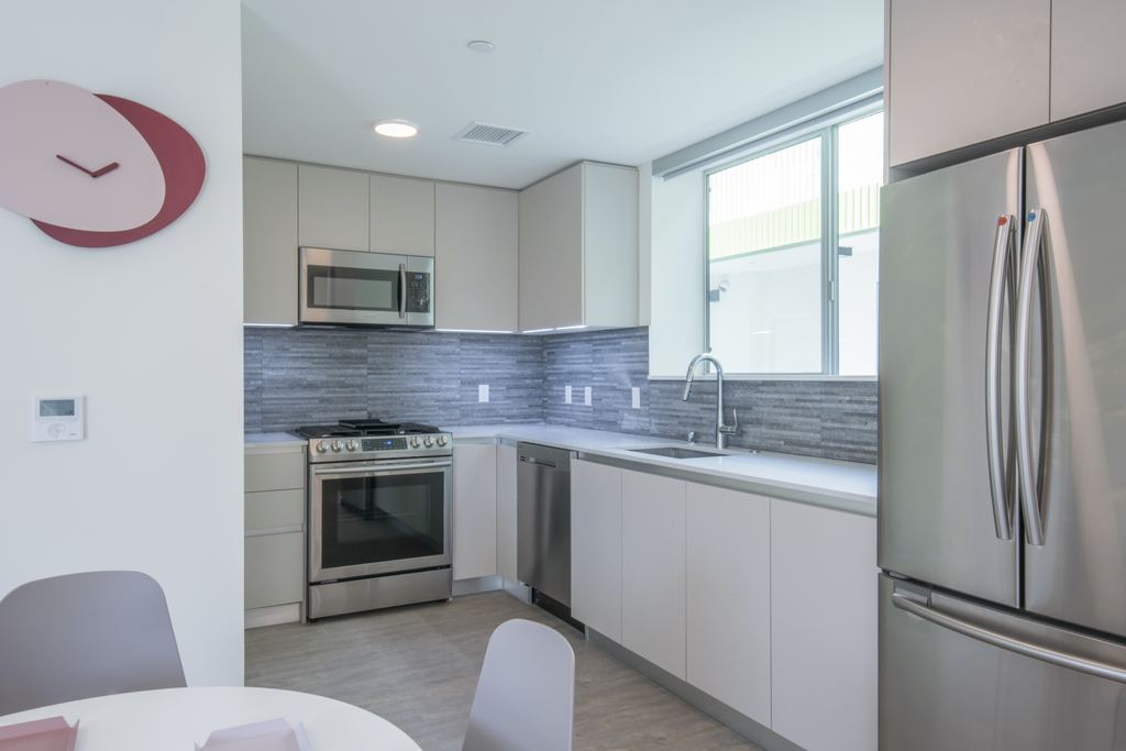 Apartment kitchen with an aluminum slider window above the sink and stainless appliances, Studio City
