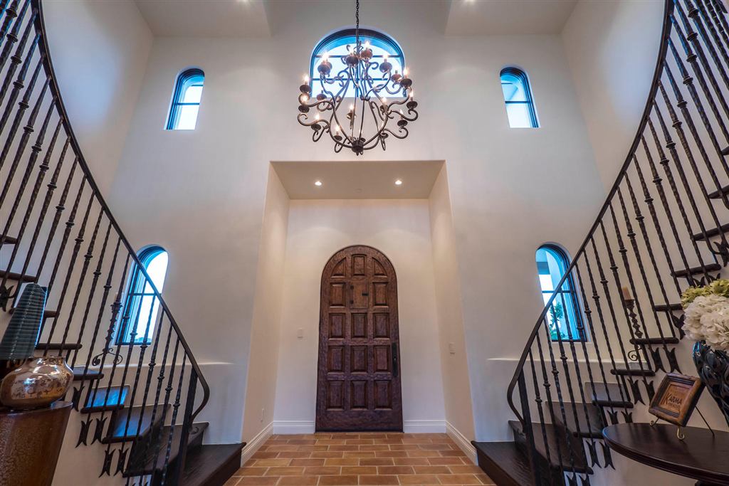 Two-story entry foyer with a wrought-iron chandelier and arched clerestory windows, Topanga