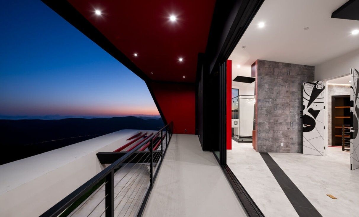 Interior gallery with sliding glass doors opening to a balcony and canyon sunset, Topanga Canyon