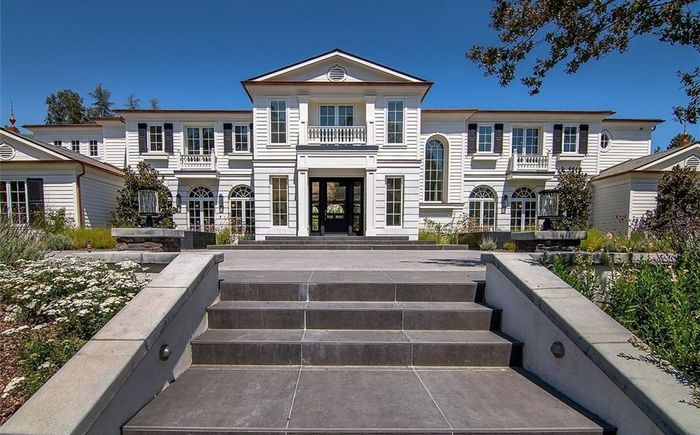 White traditional estate with divided-lite windows and a columned entry, a Window Concepts project